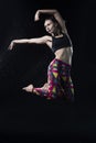 The girl dances on the floor covered with water on a black background and water splashes around her Royalty Free Stock Photo