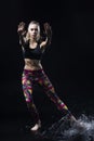 The girl dances on the floor covered with water on a black background and water splashes around her Royalty Free Stock Photo