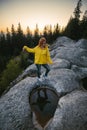 The girl dancing on the boulder, the top of rock. mirror reflection in water. Vertical photo. Witch, mystic, Active lifestyle