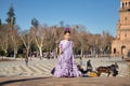 Girl dancing flamenco, posing looking at camera, in typical flamenco dress on a bridge in a nice square in Seville. Dance concept