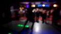 Girl dancing on stage on blurred background in the night club. Colored Abstract Blurred Light Background in the night ÃÂ¡lub