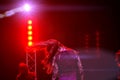 Girl dancing on stage in the rays of red light. Soft focus