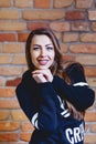 girl with dark hair in bombre on background of brick wall Royalty Free Stock Photo