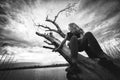 Girl and a dead tree by the lake, black and white