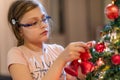 The girl decorates the Christmas tree. Children in Xmas Royalty Free Stock Photo