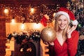 Girl decorates a Christmas tree. Very beautiful blonde girl hold bauble over Christmas tree. Merry Christmas and happy Royalty Free Stock Photo