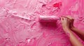 The girl decorates the wall with a pink coating