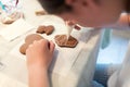 Girl decorating gingerbread cookies with icing sugar. Royalty Free Stock Photo