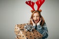 Girl with deer horns in a sweater smiles. She is shocked by such a great gift. Parents pleasantly surprised the teenager