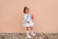 Girl in a denim jacket, knee socks and a fluffy tutu skirt holds a soda bottle in her hands Royalty Free Stock Photo
