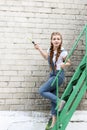 The girl makes preparing for painting a wooden surface gazebo, fence