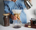 Girl in denim shirt brews alternative coffee filter. Pours water from the goose nose kettle. Close-up without face Royalty Free Stock Photo