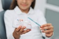 Girl in dentist chair showing how to clean teeth on dental jaw model at dental clinic. Dentistry, early prevention, oral hygiene Royalty Free Stock Photo