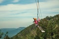 Girl descending by cables in a zip-line on forest