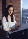 Girl designer sitting on a chair by the window and draws a sketch works as an artist