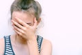 Girl in despair covers her face with hand. Stressed woman at home headache pain female portrait.