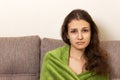 A girl in despair sit on a beige sofa. Frustrated young woman head frowning looking unhappy and stressful