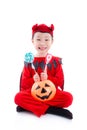 Girl in devil halloween costume sitting over white
