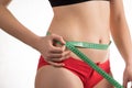 Girl on a diet measuring waist and abdomen centimeter and looks Royalty Free Stock Photo