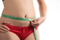 Girl on a diet measuring waist and abdomen centimeter and looks Royalty Free Stock Photo