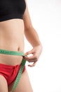 Girl on a diet measuring waist and abdomen centimeter and looks Royalty Free Stock Photo