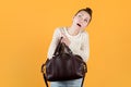 Girl diligently looking for something in her purse, looking up