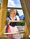 Girl in dirndl climbing on a slide Royalty Free Stock Photo