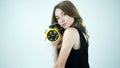 A girl with a discerning look,looks into the lens camera,a young lady with a retro clock,on a white background.