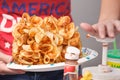 Caucasian Girl Dispensing Ketchup on Fries Royalty Free Stock Photo