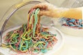 A girl in a disposable glove types chewing marmalade strips of worms.Close-up, the use of disposable gloves protective equipment