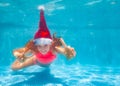 Girl dive underwater in Santa hat gesticulating Royalty Free Stock Photo