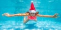 Girl dive underwater wearing Santa Claus hat Royalty Free Stock Photo