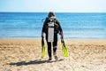 Girl diver goes along the beach towards the sea