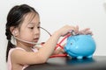 Girl doctor cure with piggy bank,