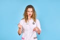 Girl doctor in medical gown with syringe. blue background. copy space