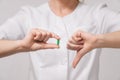 A girl doctor in white robe holds a capsule pill with a closeup medicine