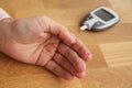 Girl does a blood sampling with a glycomer device to determine sugar level, a red drop of blood comes out on her finger, health