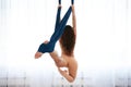 A girl does exercises in an air hammock, an air yoga hall with an air hammock, a girl training in a light room.