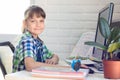 The girl does homework at the table, looked into the frame