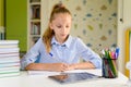 Girl does written lessons using the Internet. Royalty Free Stock Photo