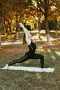 a girl does yoga asanas in a city Park. A young girl trains on the outside .