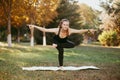 a girl does yoga asanas in a city Park. A young girl trains on the outside .