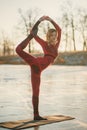 A girl does yoga in winter on the ice of the lake during the sunset Royalty Free Stock Photo