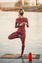 A girl does yoga in winter on the ice of the lake during the sunset Royalty Free Stock Photo