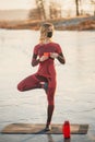 A girl does yoga in winter on the ice of the lake during the sunset Royalty Free Stock Photo