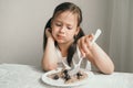 The girl doesn& x27;t want to eat porridge. The child is capricious and refuses to eat. The baby picks at food and does not Royalty Free Stock Photo