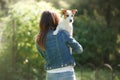 The girl with the dog in her arms. A little Jack Russell Terrier