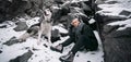 Girl with dog Malamute among rocks in winter. Royalty Free Stock Photo