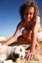 Girl with dog sits on sand Royalty Free Stock Photo