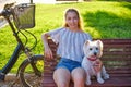 Girl with dog sitting in a park bench Royalty Free Stock Photo